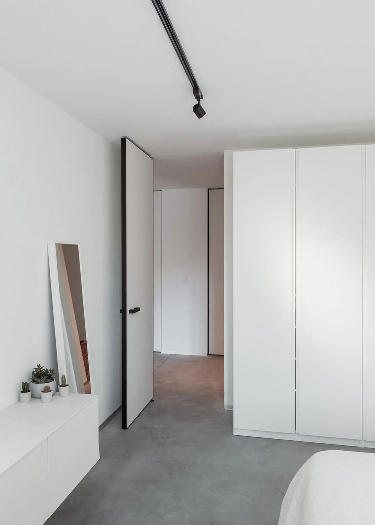 Modern frameless full-height interior pivot door with concealed pivot hinges.