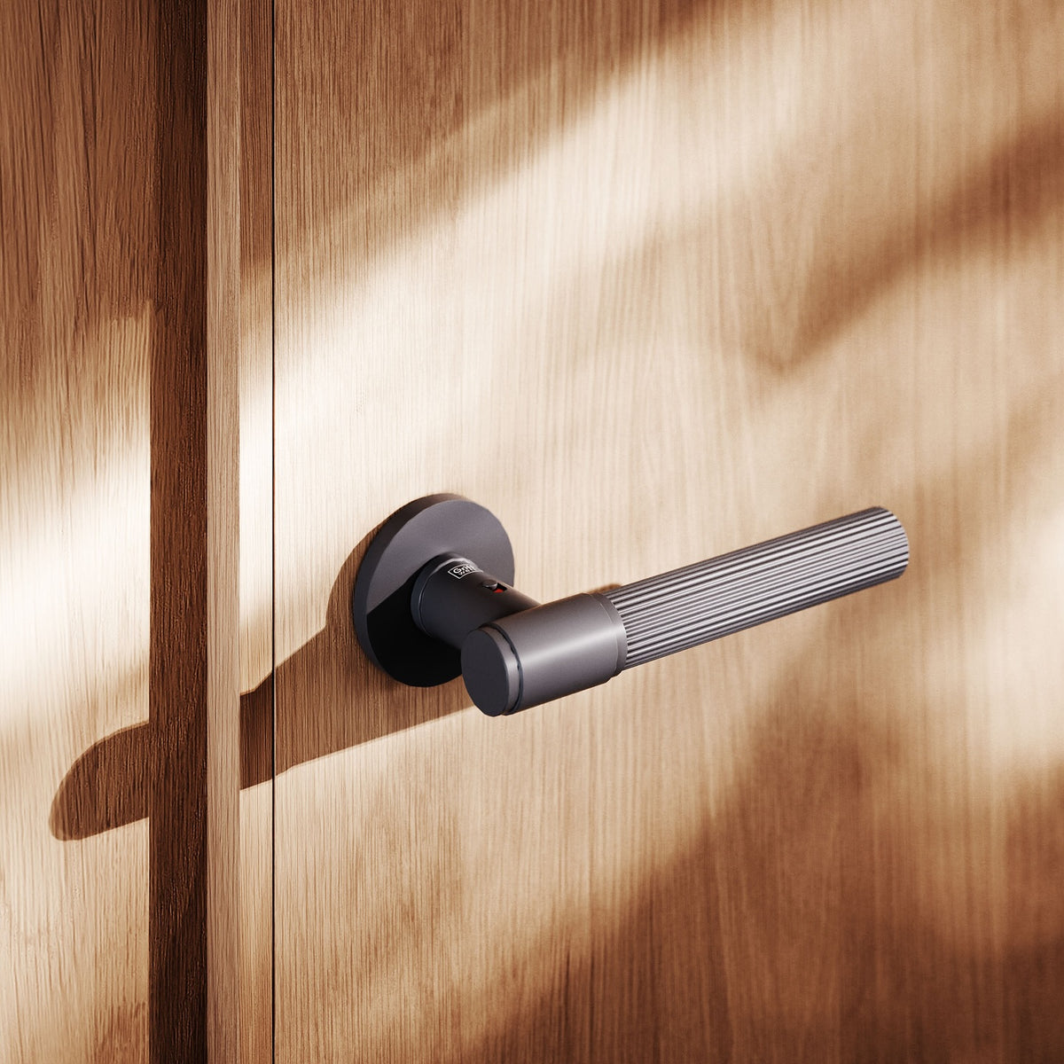 Black door lever handle featuring elegant linear-knurl detailing, and integrated privacy locking for visual purity. Model: Griffwerk Vaya 136 Aris in graphite black finish. Handle mounted on a wood veneer door.