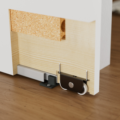 Sliding door rollers in Wingburg Invisible Trackeless Barn Door system. Detail shows recessed bottom guiding track with an adjustable guide post (T-Guide), and a double-wheel roller.